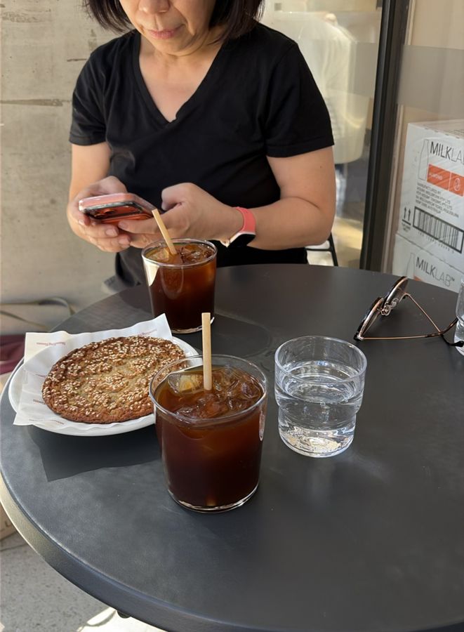 Iced coffees and a biscuit on a café table.