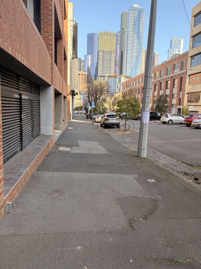 A quiet laneway with the city towers behind.